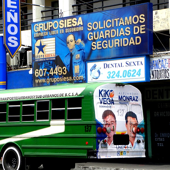Security guard recruitment sign, political ad on bus, Tijuana